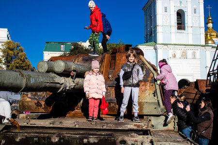 Ukrainian children have fun on the destroyed Russian military equipment, they use it like a playground. The destroyed Russian military equipment exhibition is an open air exhibition.のeditorial素材