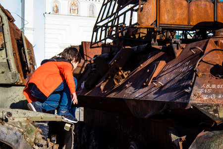 Ukrainian children have fun on the destroyed Russian military equipment, they use it like a playground. The destroyed Russian military equipment exhibition is an open air exhibition.のeditorial素材
