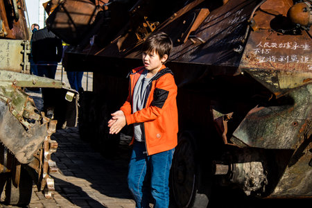 Ukrainian children have fun on the destroyed Russian military equipment, they use it like a playground. The destroyed Russian military equipment exhibition is an open air exhibition.のeditorial素材