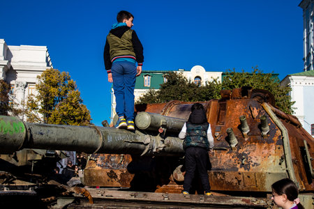 Ukrainian children have fun on the destroyed Russian military equipment, they use it like a playground. The destroyed Russian military equipment exhibition is an open air exhibition.のeditorial素材