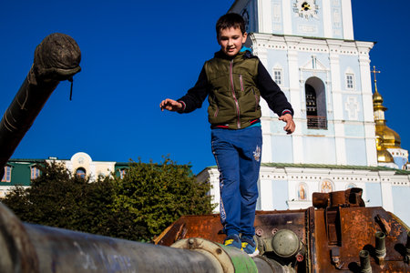 Ukrainian children have fun on the destroyed Russian military equipment, they use it like a playground. The destroyed Russian military equipment exhibition is an open air exhibition.のeditorial素材