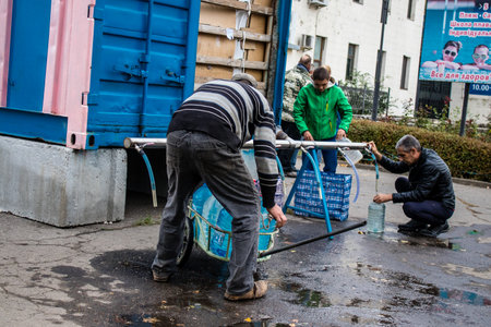 People come to get water between two bombardments. Following the Russian attack on the city of Mykolaiv, the infrastructures were affected. Water in particular is now distributed to citizens thanks to tank trucksのeditorial素材