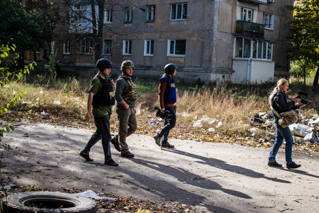 Group of television journalists and war photographers working in the city of Bakhmut, covering the war under the bombardments of the russian army, they are in the conflict zone and provide direct information on the situationのeditorial素材