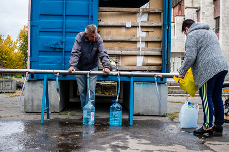 People come to get water between two bombardments. Following the Russian attack on the city of Mykolaiv, the infrastructures were affected. Water in particular is now distributed to citizens thanks to tank trucksのeditorial素材