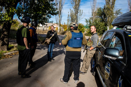 Group of television journalists and war photographers working in the city of Bakhmut, covering the war under the bombardments of the russian army, they are in the conflict zone and provide direct information on the situationのeditorial素材