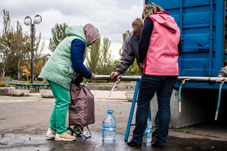 People come to get water between two bombardments. Following the Russian attack on the city of Mykolaiv, the infrastructures were affected. Water in particular is now distributed to citizens thanks to tank trucksのeditorial素材