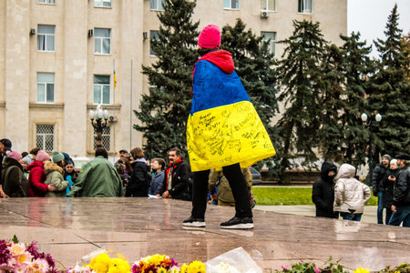 Some citizens of Kherson wearing the flag of Ukraine in the form of a cape celebrate the liberation of the city on Freedom Square in the city center. Russian troops left Kherson after a nine-month occupation and a counter offensive by the Ukrainian army.のeditorial素材