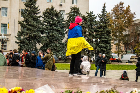 Some citizens of Kherson wearing the flag of Ukraine in the form of a cape celebrate the liberation of the city on Freedom Square in the city center. Russian troops left Kherson after a nine-month occupation and a counter offensive by the Ukrainian army.のeditorial素材