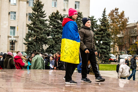 Some citizens of Kherson wearing the flag of Ukraine in the form of a cape celebrate the liberation of the city on Freedom Square in the city center. Russian troops left Kherson after a nine-month occupation and a counter offensive by the Ukrainian army.のeditorial素材