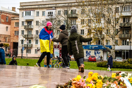 Some citizens of Kherson wearing the flag of Ukraine in the form of a cape celebrate the liberation of the city on Freedom Square in the city center. Russian troops left Kherson after a nine-month occupation and a counter offensive by the Ukrainian army.のeditorial素材