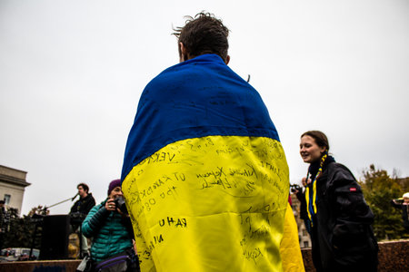 Some citizens of Kherson wearing the flag of Ukraine in the form of a cape celebrate the liberation of the city on Freedom Square in the city center. Russian troops left Kherson after a nine-month occupation and a counter offensive by the Ukrainian army.のeditorial素材