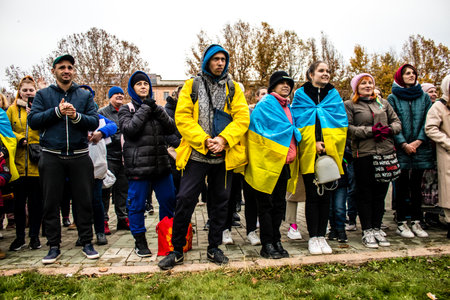 Some citizens of Kherson wearing the flag of Ukraine in the form of a cape celebrate the liberation of the city on Freedom Square in the city center. Russian troops left Kherson after a nine-month occupation and a counter offensive by the Ukrainian army.のeditorial素材