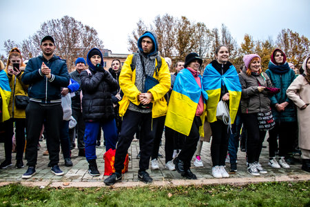 Some citizens of Kherson wearing the flag of Ukraine in the form of a cape celebrate the liberation of the city on Freedom Square in the city center. Russian troops left Kherson after a nine-month occupation and a counter offensive by the Ukrainian army.のeditorial素材