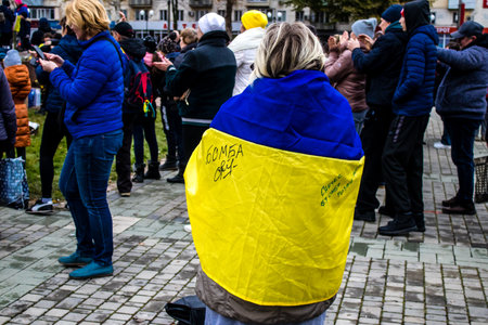 Some citizens of Kherson wearing the flag of Ukraine in the form of a cape celebrate the liberation of the city on Freedom Square in the city center. Russian troops left Kherson after a nine-month occupation and a counter offensive by the Ukrainian army.のeditorial素材