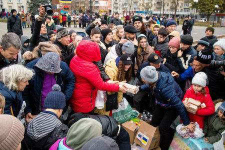 Residents of Kherson, Ukraine, receive food supplies in Freedom Square. The tension is very strong and people are very exasperated. International humanitarian aid is organized when people lack everything.のeditorial素材