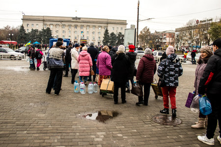 Residents of Kherson in Ukraine, collecting drinkable water at Freedom Square. International humanitarian aid is organized when people lack everything. The Russian army has bombed the infrastructure of the city and the water supply is completely cut off. のeditorial素材