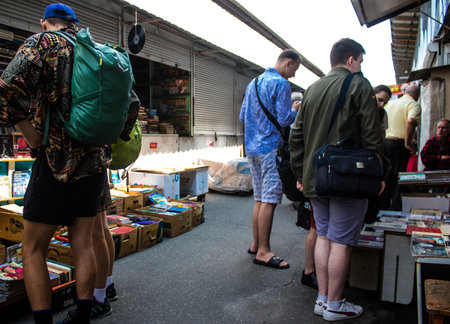 People shopping at book market Petrivka located in Kyiv, Ukraine. Famous for its great range of books. Sprawling open air market with stalls selling secondhand books. Despite the war and the fact that there are no tourists, this place remains very popularのeditorial素材