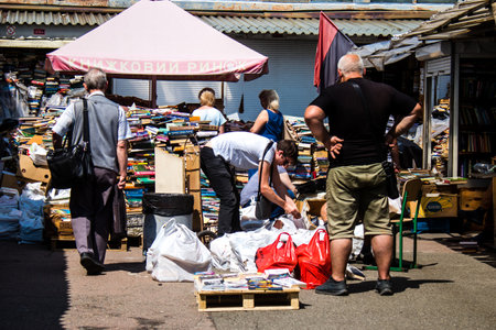 People shopping at book market Petrivka located in Kyiv, Ukraine. Famous for its great range of books. Sprawling open air market with stalls selling secondhand books. Despite the war and the fact that there are no tourists, this place remains very popularのeditorial素材