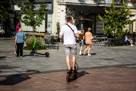 Lviv, Ukraine, August 25, 2024 People rolling with an electric scooter in the streets of Lviv, operating with a small utility internal combustion engines and a deck in the center.の写真素材