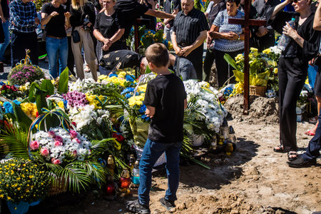 Lviv, Ukraine, August 23, 2024 Family and friends await the burial of three Ukrainian soldiers who died in a battle with the Russian army at the Field of Mars at the Lviv military cemetery.のeditorial素材