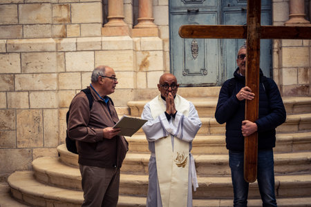 Jerusalem, Israel, 19 February 2026  Italian Christian pilgrims led by a priest conduct an official procession along the Via Dolorosa in the Old City. Devotees carry a cross through narrow streets.のeditorial素材