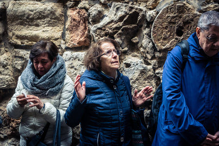 Jerusalem, Israel, 19 February 2026  Italian Christian pilgrims led by a priest conduct an official procession along the Via Dolorosa in the Old City. Devotees carry a cross through narrow streets.のeditorial素材