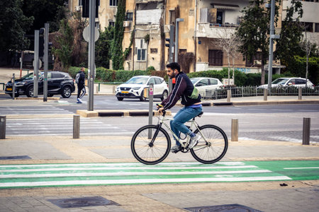 Tel Aviv, Israel, March 7, 2026 A person cycling through the city, using sustainable urban transport...