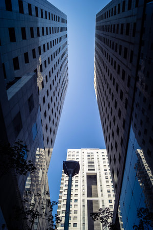 Tel Aviv, Israel, March 17, 2026 Detailed view focusing on the geometric alignment and vertical scale of high-rise commercial buildings within the urban core. The image captures the rhythmic pattern of steel frames and glass panels reaching toward the horのeditorial素材