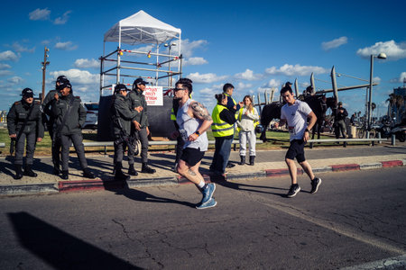 Tel Aviv, Israel, February 27, 2026 Marathon participants run past security forces standing guard...