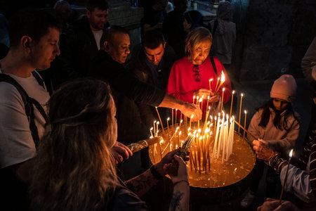 JERUSALEM, ISRAEL - FEBRUARY 21, 2026 Christian pilgrims lighting prayer candles in the mystic and...