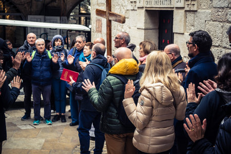 Jerusalem, Israel, 19 February 2026  Italian Christian pilgrims led by a priest conduct an official procession along the Via Dolorosa in the Old City. Devotees carry a cross through narrow streets.のeditorial素材