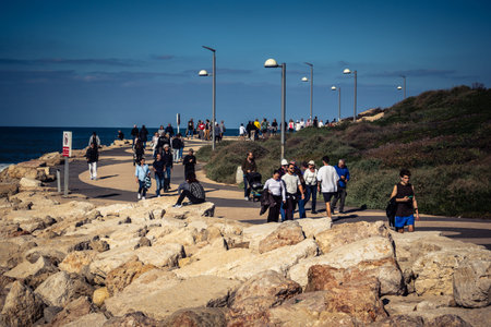 Tel Aviv, Israel, January 3, 2026 Passersby stroll along the Tel Aviv promenade facing the Mediterranean Sea, demonstrating daily resilience despite regional security tensions in the Middle East.のeditorial素材