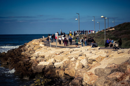 Tel Aviv, Israel, January 3, 2026 Passersby stroll along the Tel Aviv promenade facing the Mediterranean Sea, demonstrating daily resilience despite regional security tensions in the Middle East.のeditorial素材