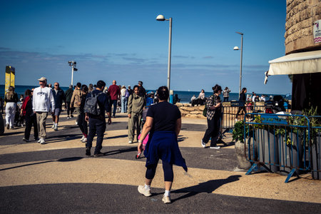 Tel Aviv, Israel, January 3, 2026 Passersby stroll along the Tel Aviv promenade facing the Mediterranean Sea, demonstrating daily resilience despite regional security tensions in the Middle East.のeditorial素材