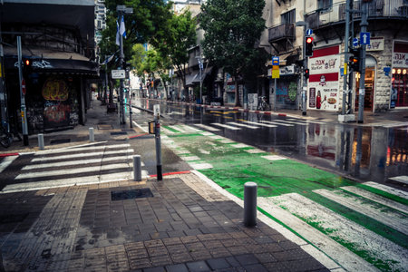Tel Aviv, Israel, March 21, 2026 Street view of Tel Aviv under the rain with light reflections on the wet pavement and moody urban atmosphere.のeditorial素材