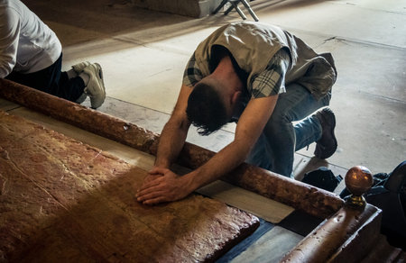 JERUSALEM, ISRAEL - FEBRUARY 16, 2026 Close-up of Christian pilgrims touching and blessing the Stone...