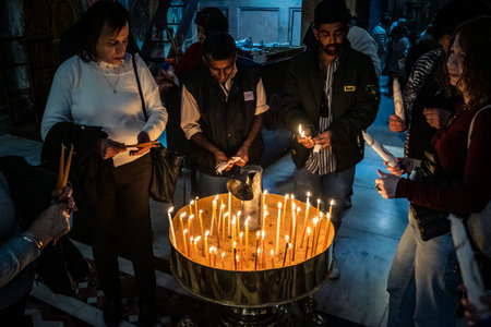 JERUSALEM, ISRAEL - FEBRUARY 21, 2026 Christian pilgrims lighting prayer candles in the mystic and...