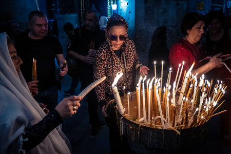 JERUSALEM, ISRAEL - FEBRUARY 21, 2026 Christian pilgrims lighting prayer candles in the mystic and...