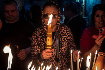 JERUSALEM, ISRAEL - FEBRUARY 21, 2026 Christian pilgrims lighting prayer candles in the mystic and...
