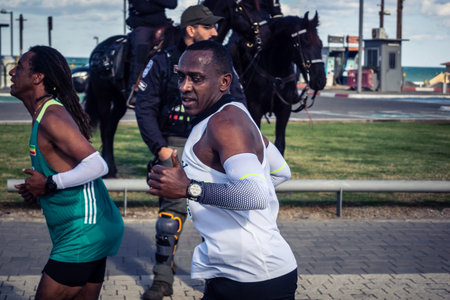 Tel Aviv, Israel, February 27, 2026 A participant makes direct eye contact and waves at the camera, capturing a moment of personal connection and endurance during the city marathon.のeditorial素材