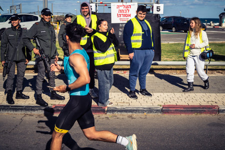 Tel Aviv, Israel, February 27, 2026 Marathon participants run past security forces standing guard...