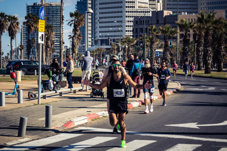 Tel Aviv, Israel, February 27, 2026 A participant makes direct eye contact and waves at the camera, capturing a moment of personal connection and endurance during the city marathon.のeditorial素材