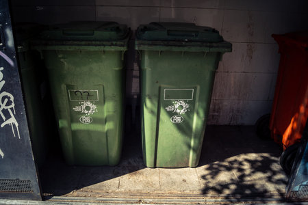 Tel Aviv, Israel, February 26 2026, Urban waste bins on Sheinkin Street, daily city life meeting Bauhaus architecture, authentic street contrast, raw textures under the sun, rhythmic geometry and cascading light observed by I.C.R.U.のeditorial素材