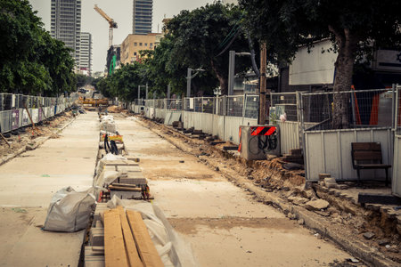Tel Aviv, Israel, March 14, 2026 Construction equipment for the new tramway stands motionless during Shabbat as the desert sand reclaims the urban landscape, creating a scene of eerie stillness and suspended progress.のeditorial素材