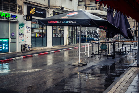 Tel Aviv, Israel, March 21, 2026 Street view of Tel Aviv under the rain with light reflections on the wet pavement and moody urban atmosphere.のeditorial素材