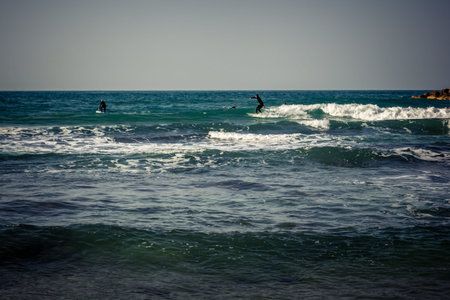Tel Aviv, Israel, January 25, 2026 Young people surf on the beach in Tel Aviv. This beach remains an...