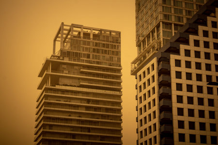 Tel Aviv, Israel, March 14, 2026 A thick layer of desert sand and dust blankets the streets during a Sharav atmospheric phenomenon, creating a surreal orange glow and reducing visibility across the metropolitan area.のeditorial素材