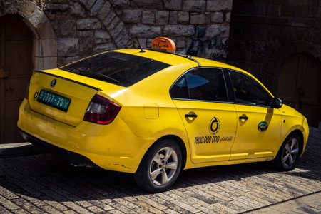 Hebron, West Bank, Palestine, March 28, 2026 A traditional yellow Palestinian taxi is parked along...