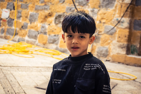 Hebron, West Bank, Palestine, March 28, 2026 Palestinian children are seen smiling at the camera, riding bicycles through narrow alleys and eating ice cream in the historic stone streets of Hebron's old city. These scenes take place in the H2 area, a sectのeditorial素材