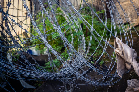 Hebron, West Bank, Palestine, March 28, 2026 Razor wire, metal fencing, and military barriers are...
